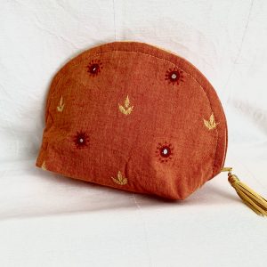 Une pochette demi-lune en coton orange incrusté de petits miroirs