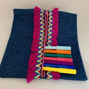 Une trousse plate en denim avec un galon rose